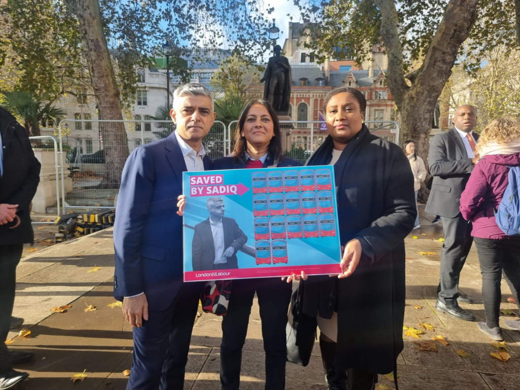 Bell holding a Saved by Sadiq sign with the Mayor of London, Sadiq Khan. 