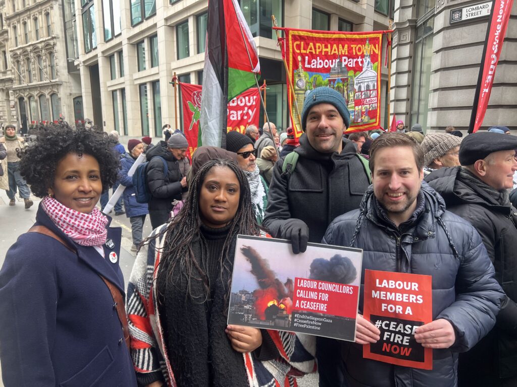 Bell stands with local Lambeth Labour councillors Ibtisam Adem, Martin Abrams, and Andrew Collins. She holds a sign that says Labour Councillors calling for a ceasefire.
